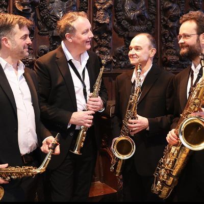 Quartz Saxophone Quartet in suits smiling at each other